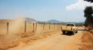 backroad with a truck driving kicking up dust