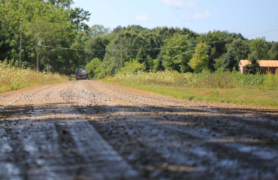 close up photo of an unpaved road with a truck in the distance