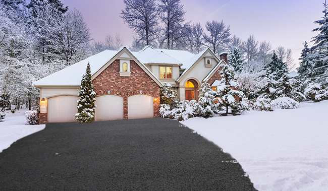 photo of a house in the middle of winter with a clean driveway