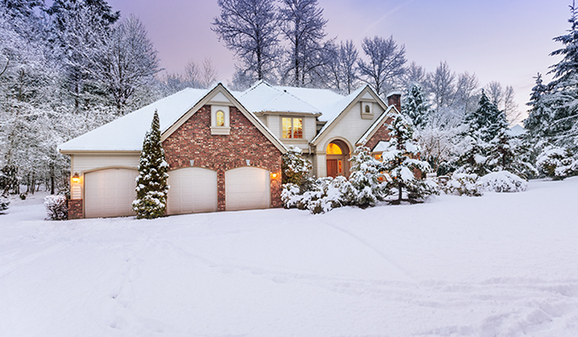 Photo of a home in the middle of winter with a driveway covered in snow