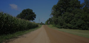 Photo of a road half treated with dust control