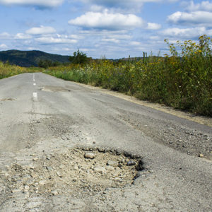 Photo of a road with deep potholes