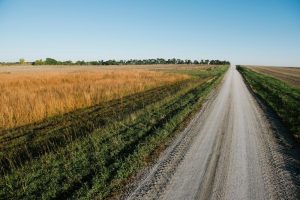 Stabilize roads with Ohio Gravel Road Maintenance from Great Lakes Chloride image shows road passing field