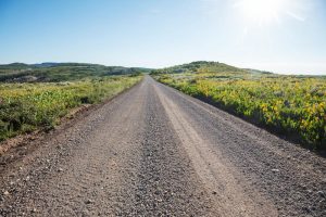 Contact Great Lakes Chloride for help with Michigan Gravel Road Maintenance image shows road through field
