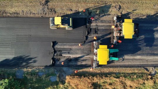 Implement effective calcium chloride solutions from Great Lakes Chloride for your next Indiana Road Reclamation project image shows workers and machines on road