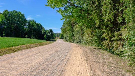 Contact Great Lakes Chloride for assistance with Ohio Gravel Road Erosion Control image shows gravel road between grass and trees